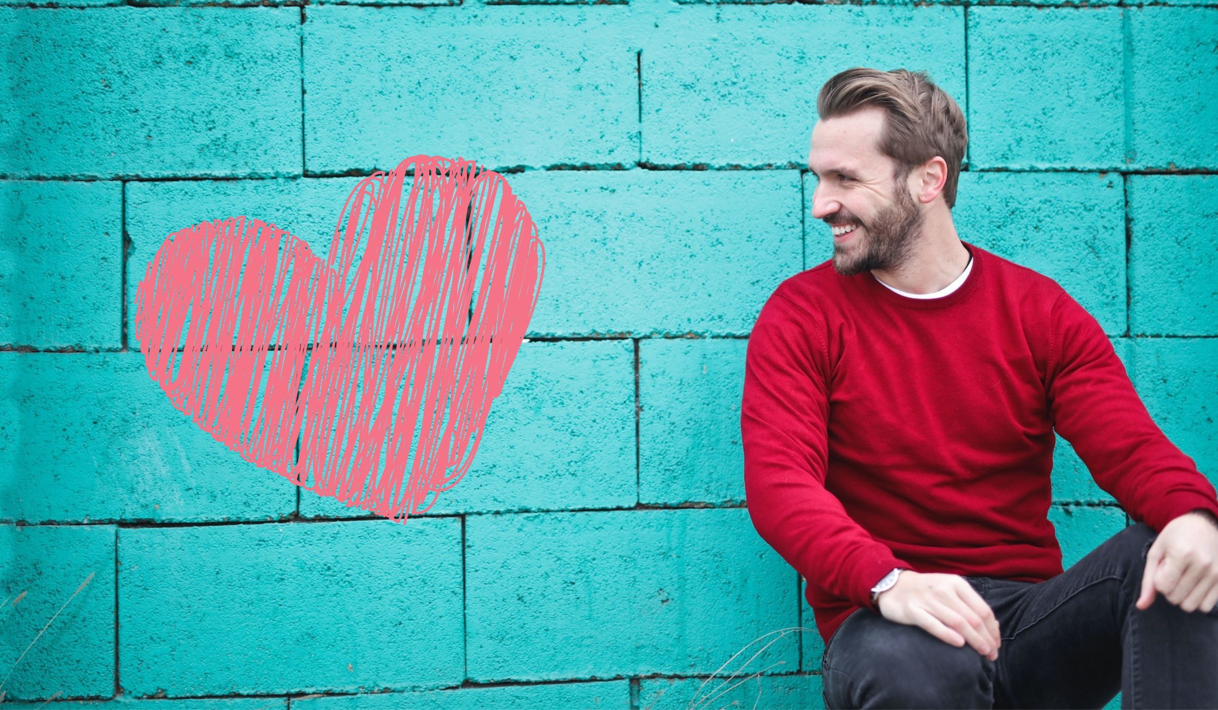 apelidos carinhosos - imagem de um homem sorridente em frente a um muro azul com um coração rosa