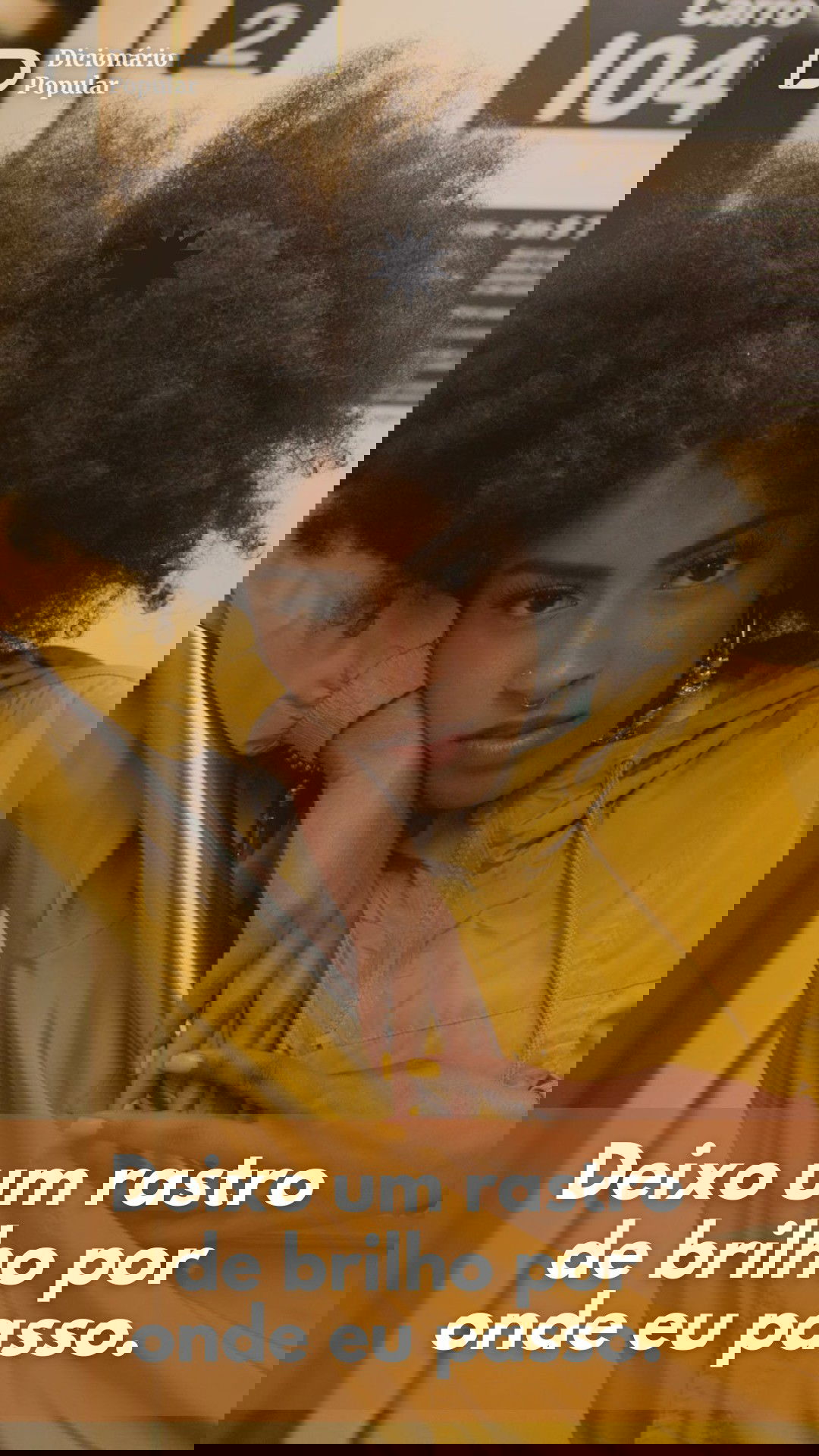 Mulher de casaco amarelo encara a câmera fixamente com a frase para biografia do Instagram na parte d ebaixo