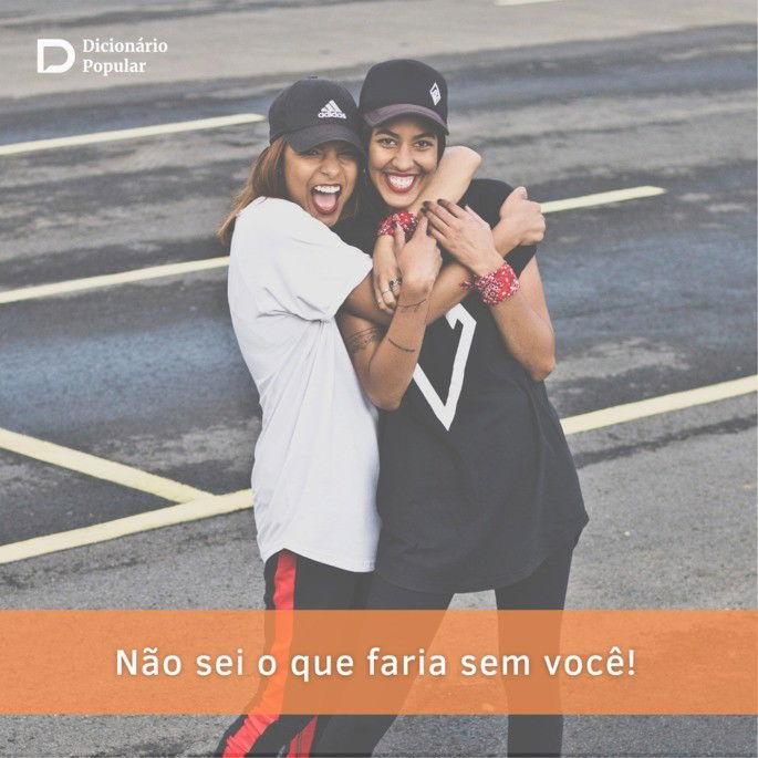 Duas mulheres vestindo bonés pretos e roupa de academia se abraçam em um estacionamento