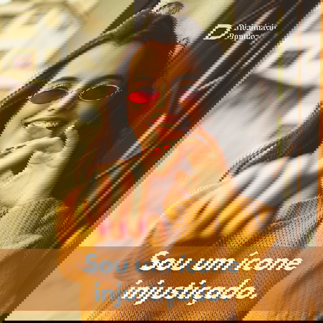 Mulher de óculos vermelhos e casaco mostarda sorri e aponta para a câmera