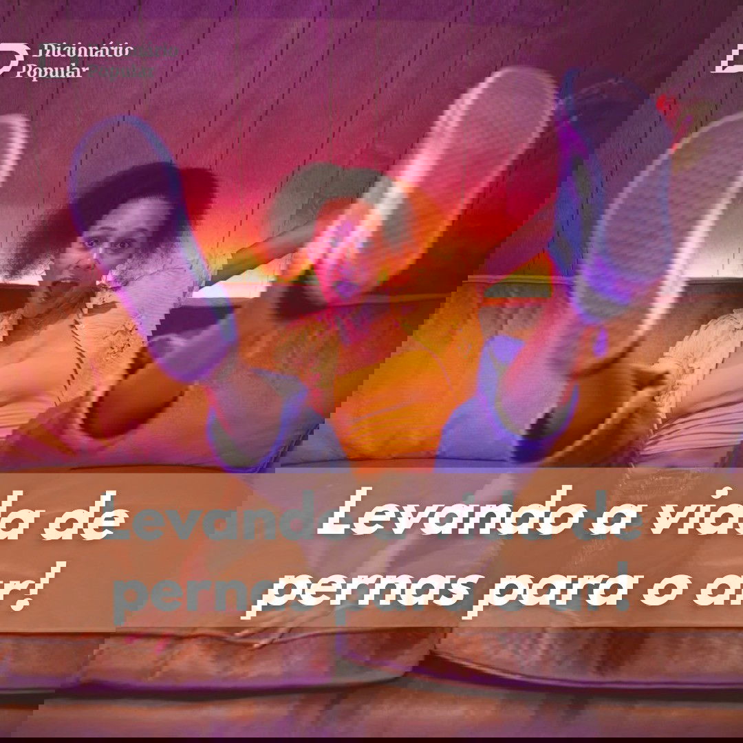 Menina de blusa amarela, calça jeans e tênis branco sentada no sofá com os pés para cima