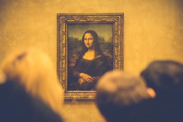 Quadro Monalisa exposto no museu com várias pessoas observando